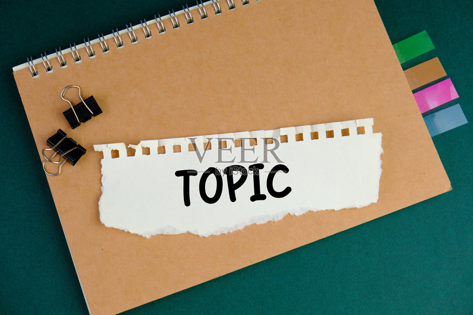 绿色背景上撕裂的白纸，上面写着“主题”，象征着教育和学习的概念照片摄影图片