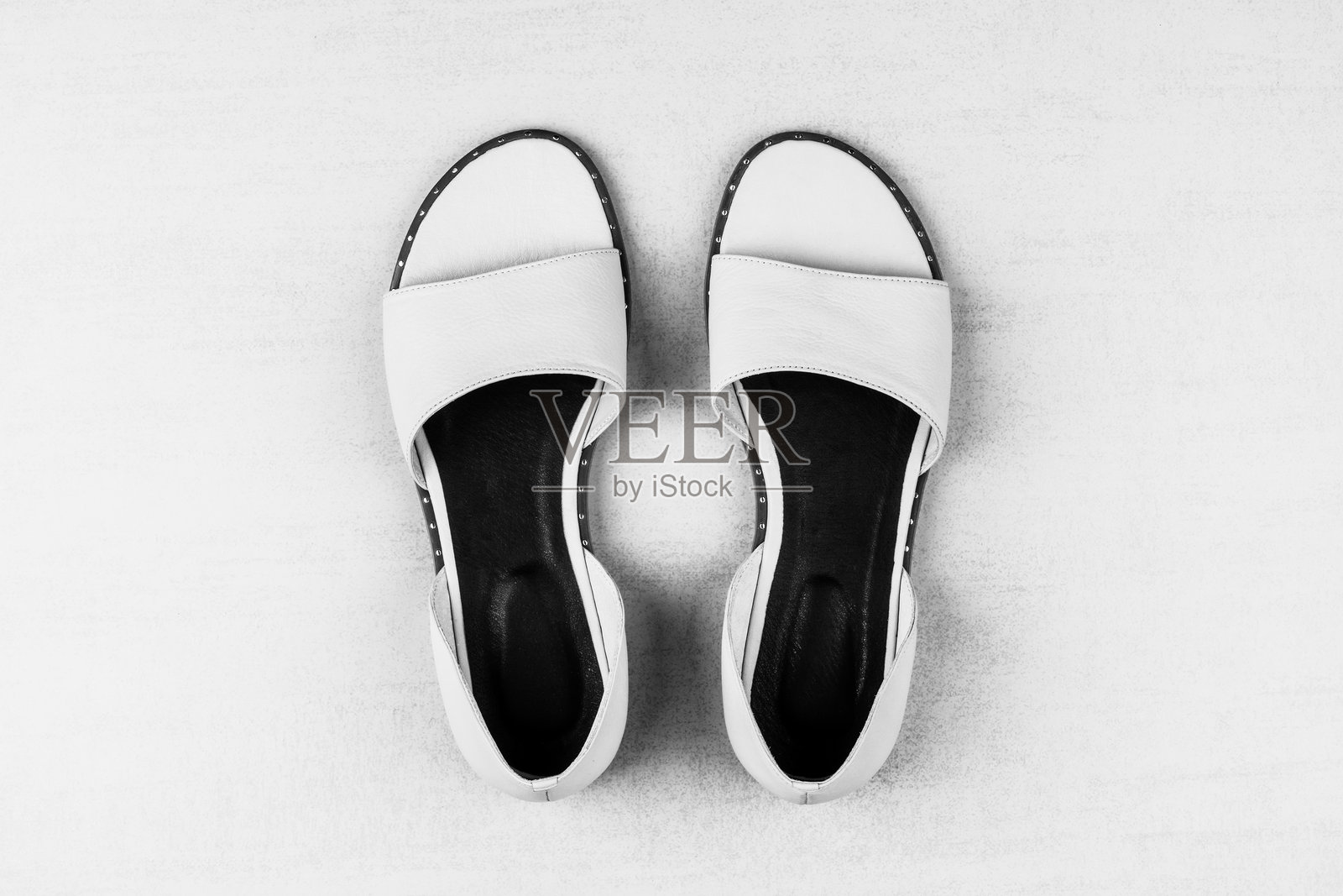 俯视黑白照片：白色背景上的女性夏季凉鞋照片摄影图片