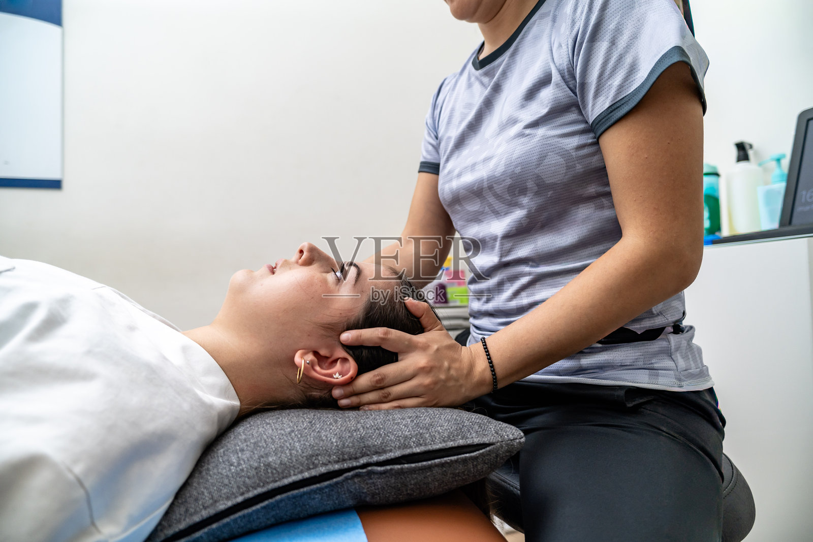 女物理治疗师正在为患者按摩颈部和头部照片摄影图片