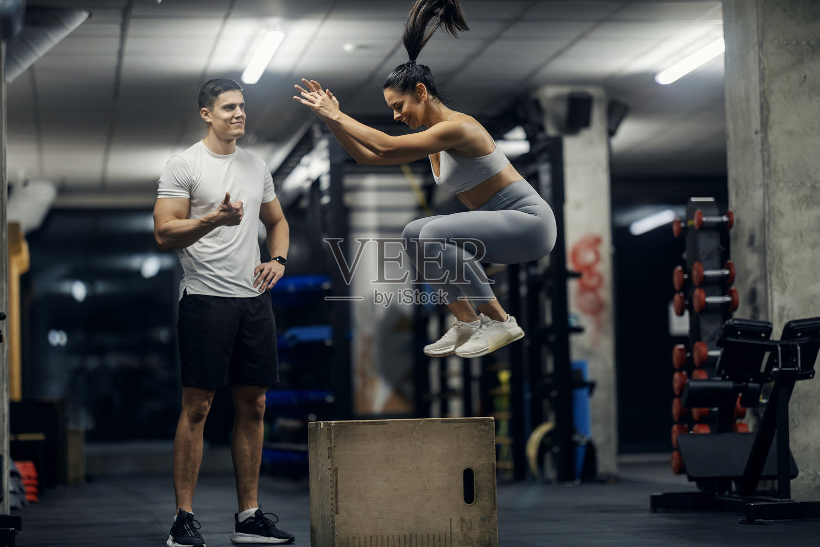 女子在私人教练指导下进行箱式跳跃锻炼照片摄影图片