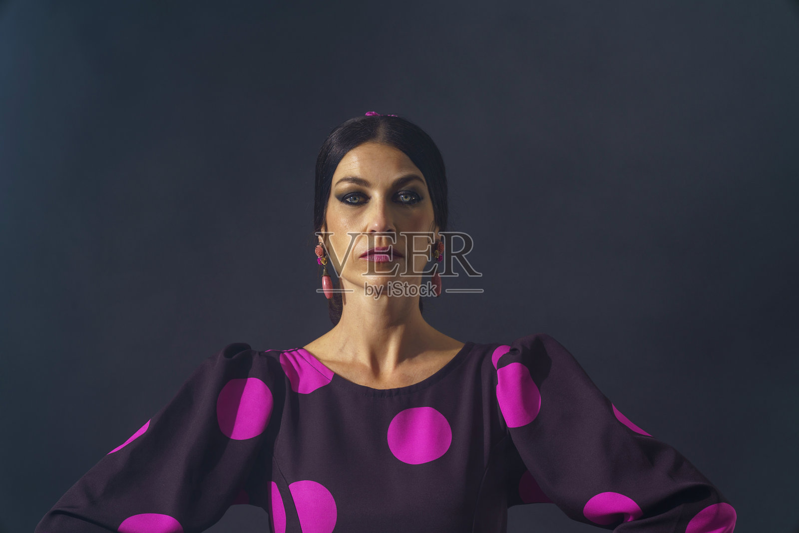 一位女士双手叉腰站立，展现出对西班牙弗拉门戈文化的坚定决心和热情照片摄影图片