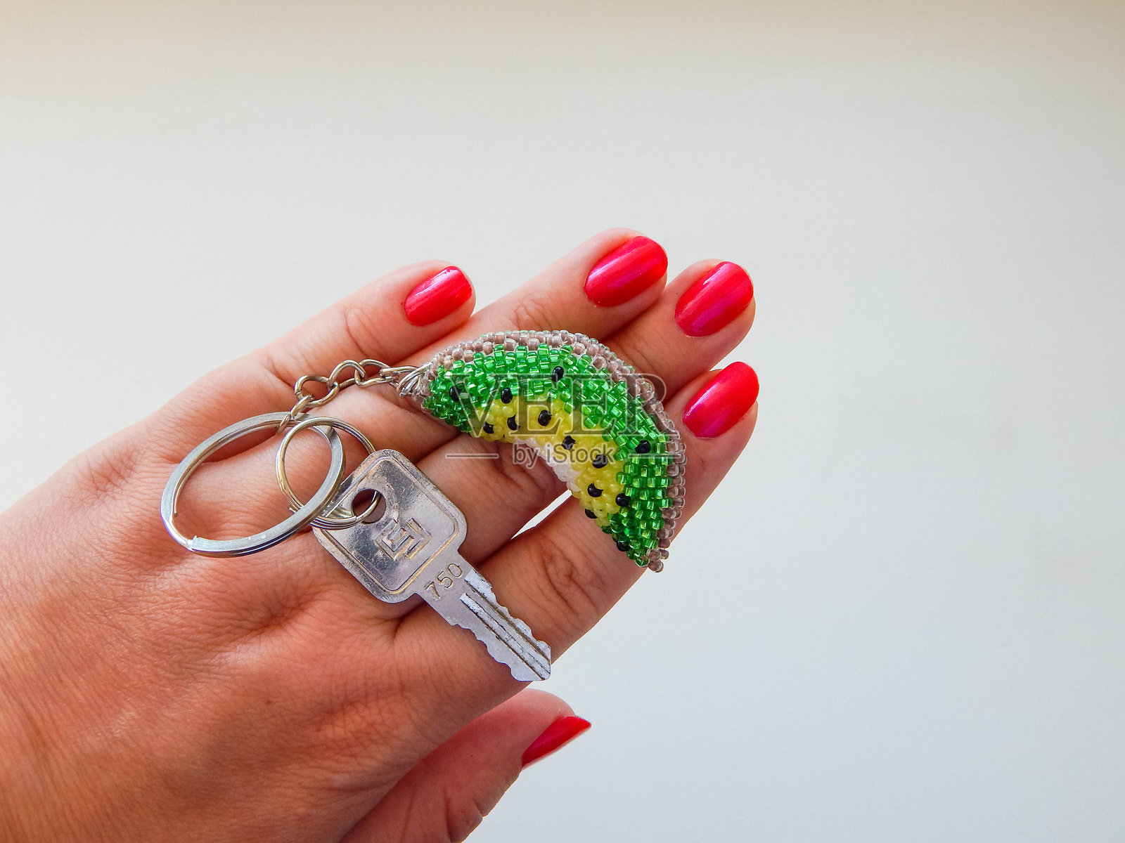 一个水果钥匙扣放在女人的手掌上。女人的手里拿着一个水果钥匙扣。照片摄影图片