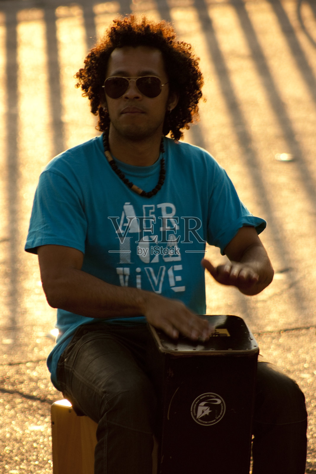 日落时分,一位音乐家在巴塞罗那街头演奏打击乐。照片摄影图片