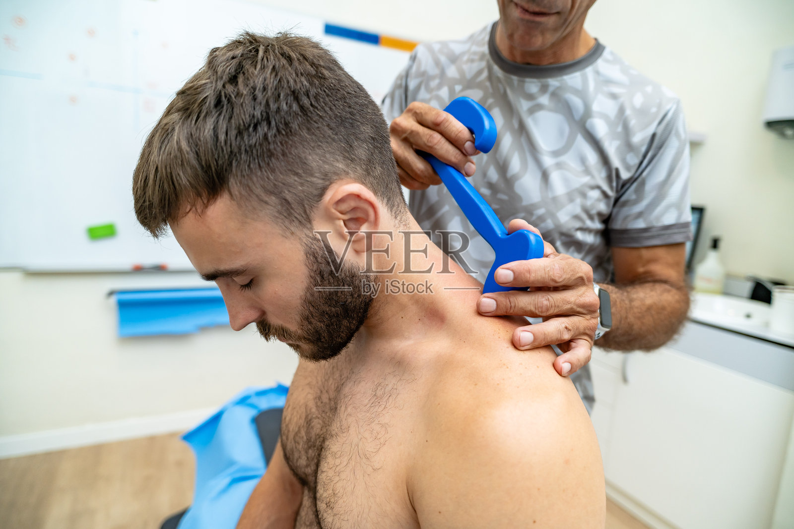 理疗师使用器械辅助软组织松动术治疗颈部照片摄影图片