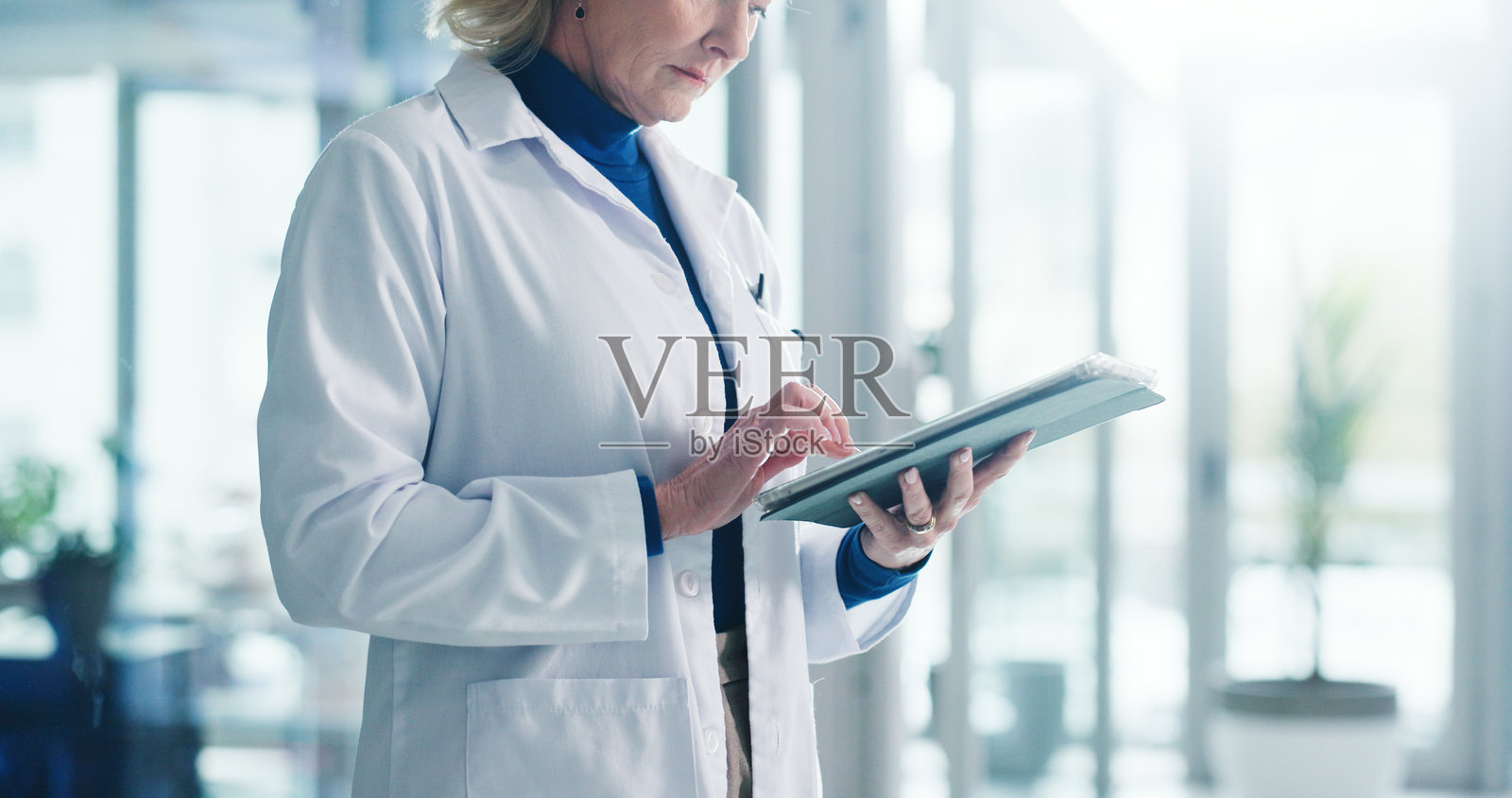 科技，成熟的女性和医生在医院进行医学研究、管理或沟通。平板电脑、电子邮件和专业的女性医护人员在诊所大厅进行在线联系。照片摄影图片