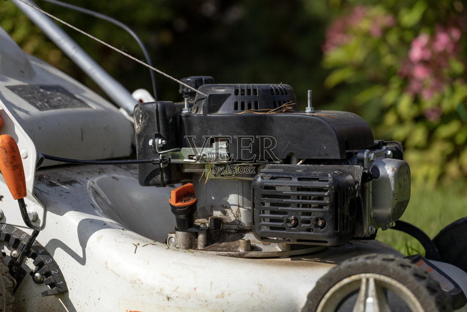 近距离拍摄的割草机发动机，展示了可见的组件和细节。照片摄影图片