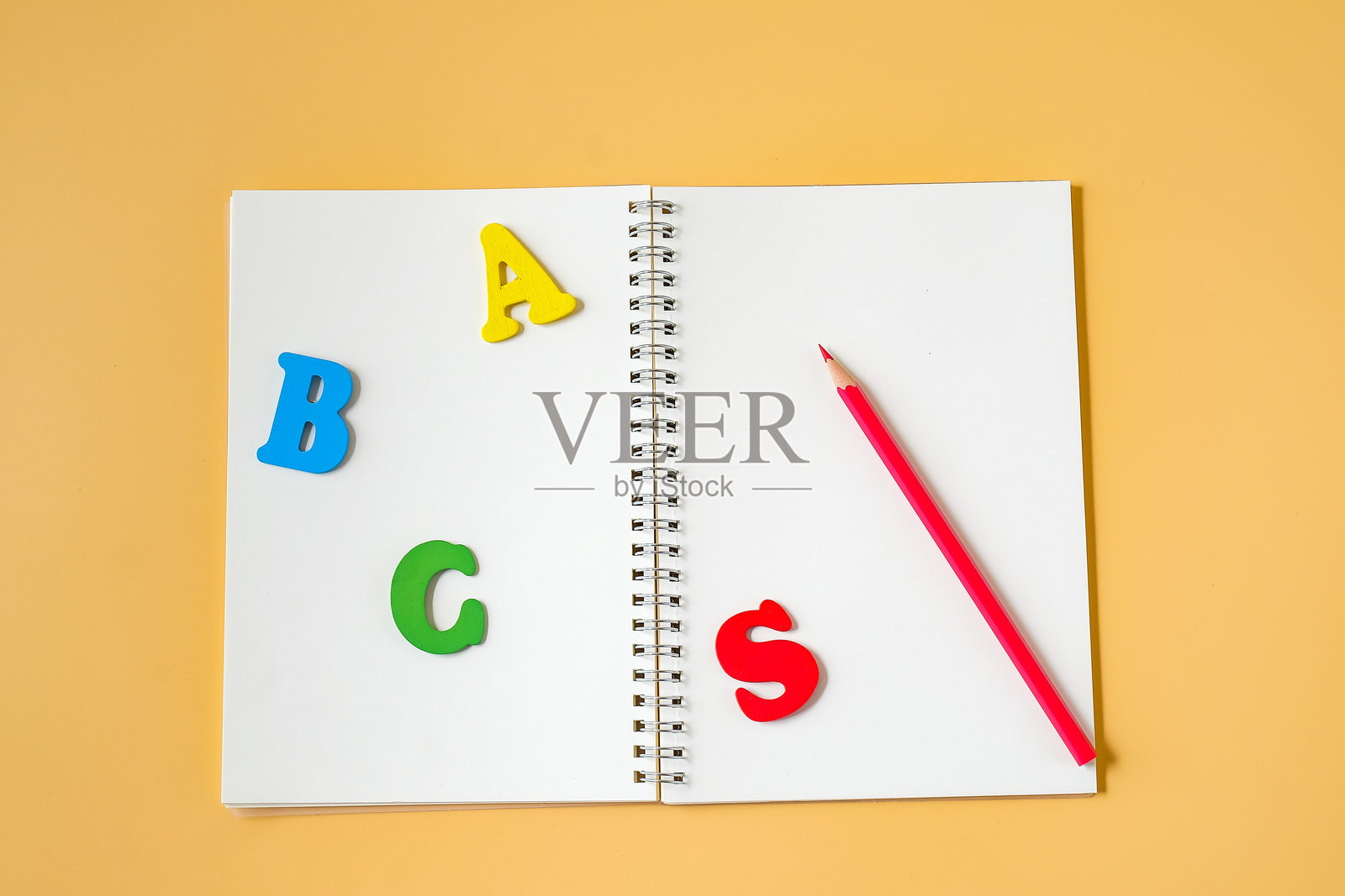 彩色的背景上放着笔记本、彩色铅笔和文字。照片摄影图片