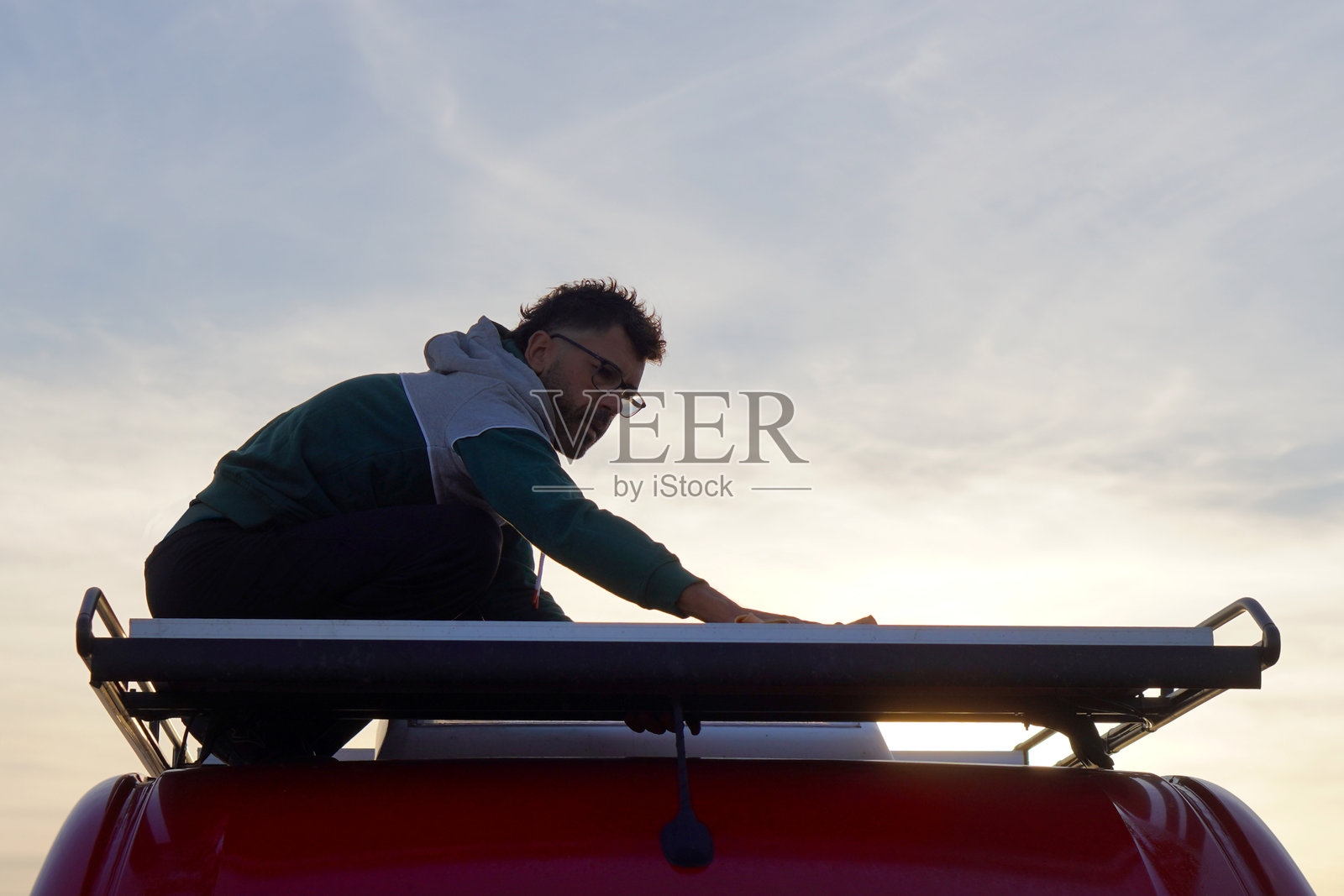 数字游民，公路旅行，可持续生活，一名男子正在维护他的房车的太阳能电池板照片摄影图片