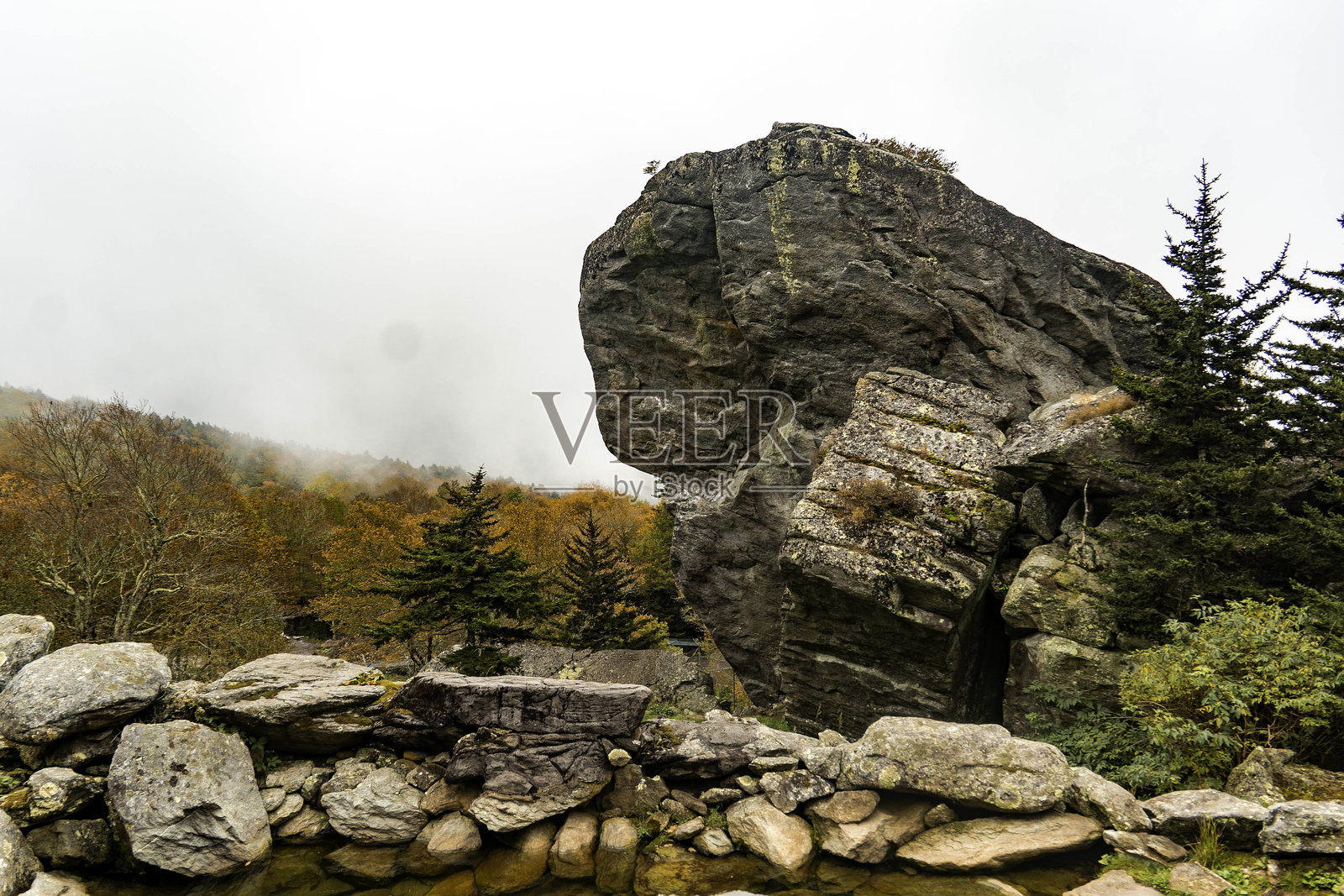长满苔藓的草坡山脊上巨大的花岗岩露头，暗示着地质趣味和徒步探险照片摄影图片
