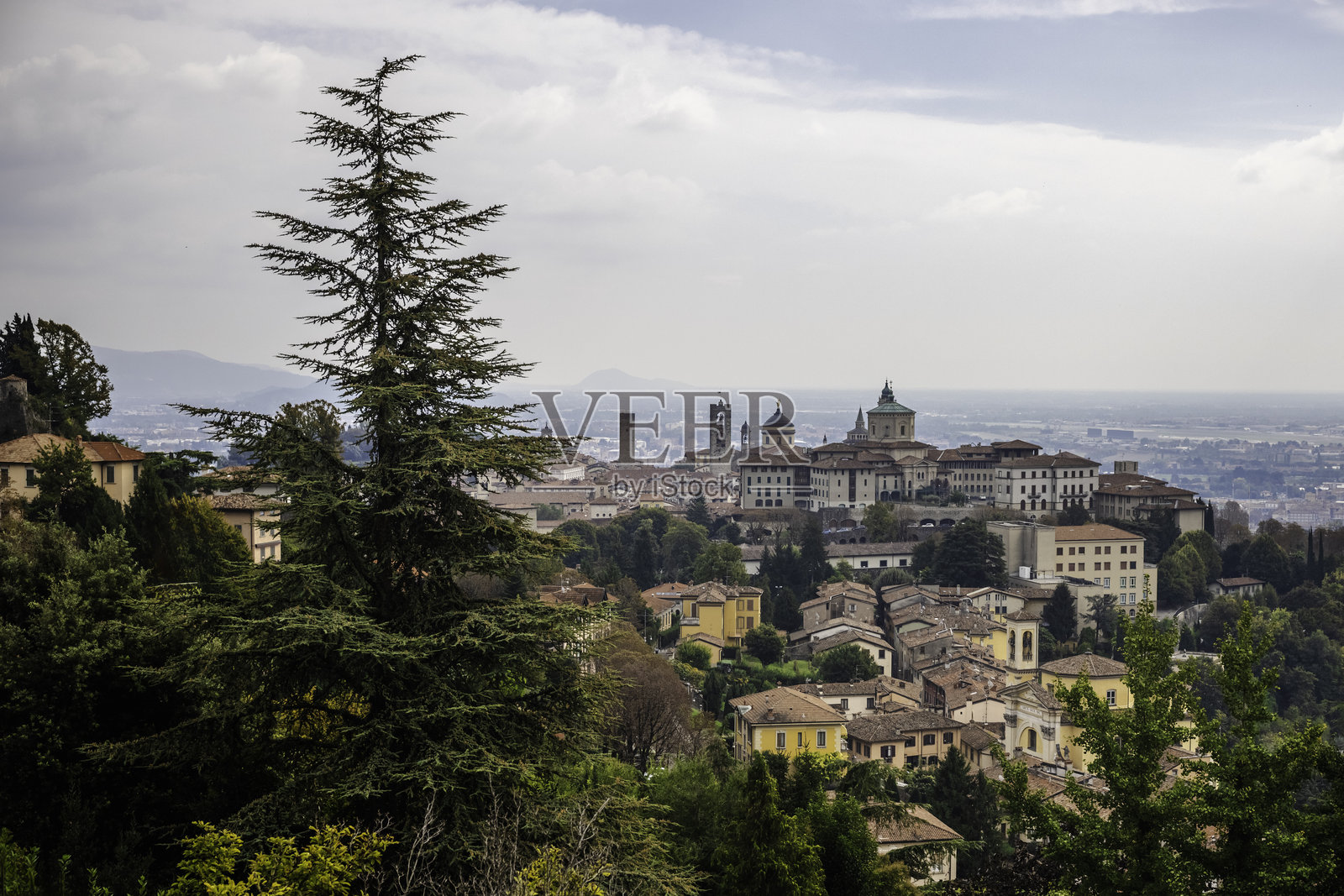 阴天时，贝加莫上城的全景，历史悠久的塔楼和圆顶被绿意环绕照片摄影图片