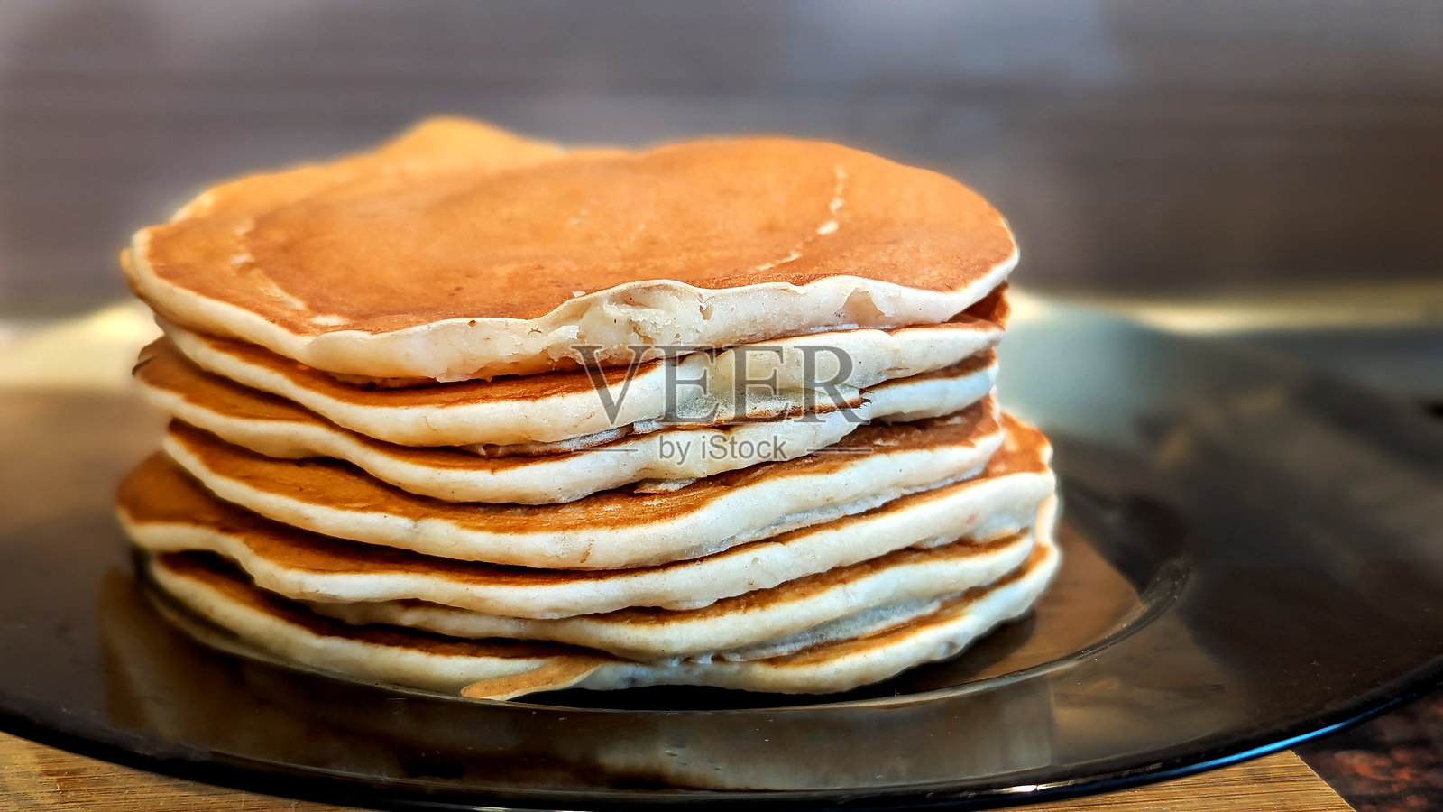 蓬松金黄的自制煎饼叠放在一起，是美味的早餐选择照片摄影图片