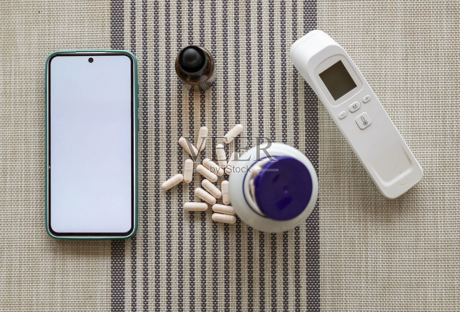 智能手机、温度计和药品，象征着远程医疗照片摄影图片