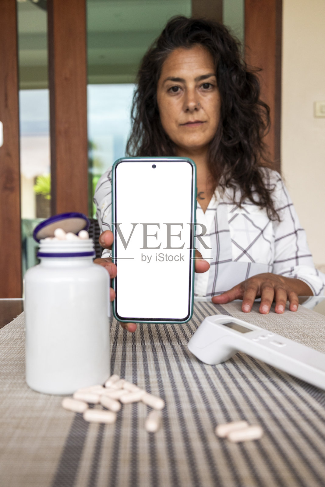 一位女士正在使用智能手机，示意进行远程医疗咨询照片摄影图片