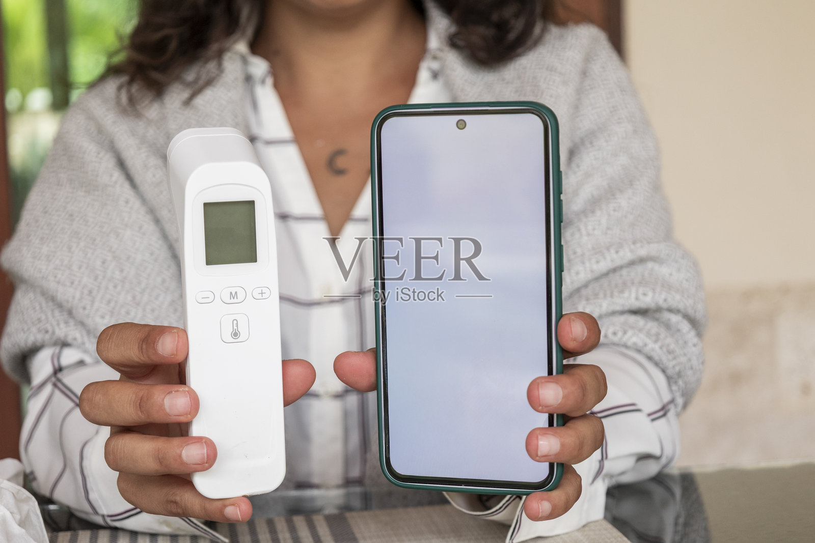 一个人正在测量体温并使用在线医生应用程序照片摄影图片