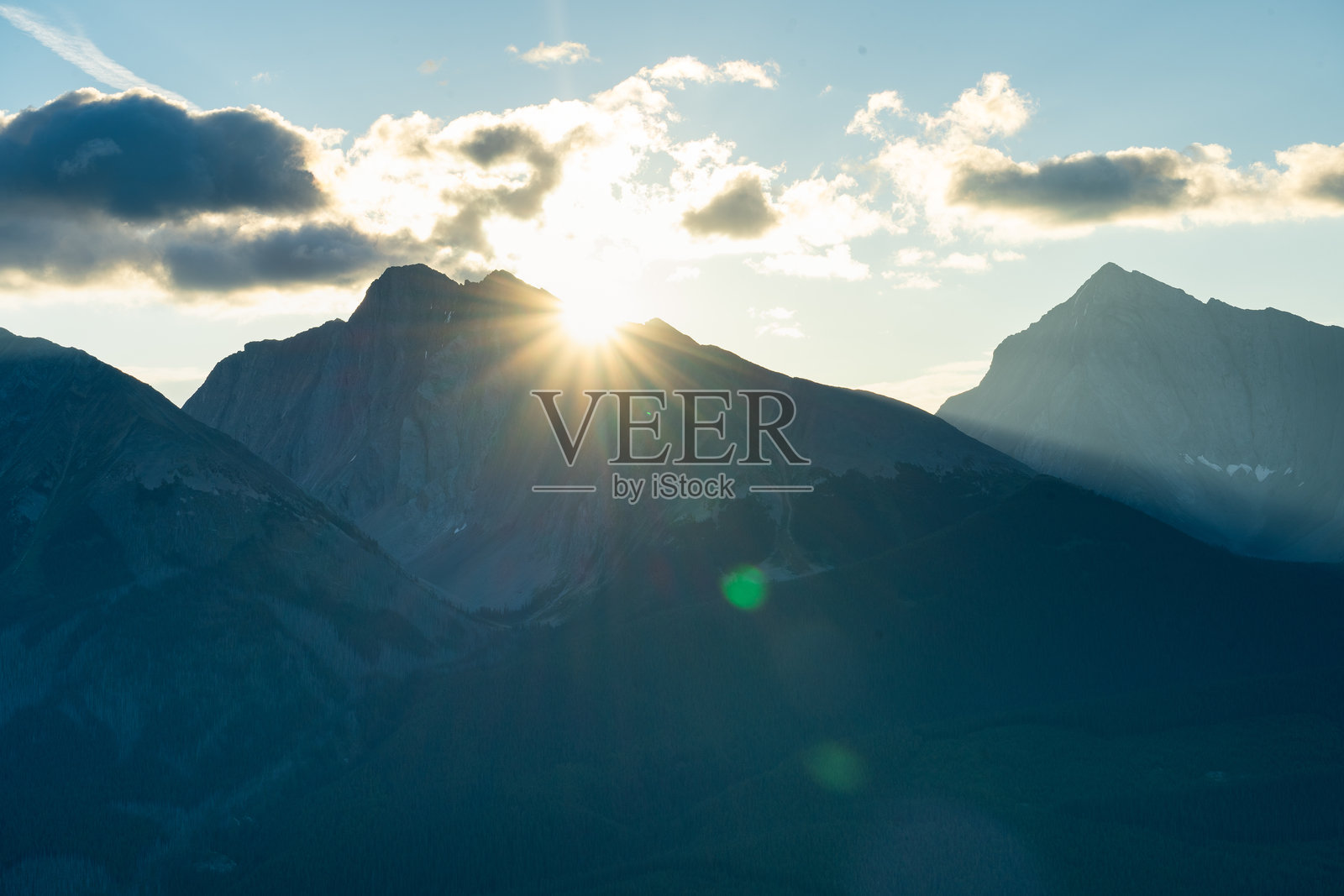 阳光照亮山峰，云彩勾勒出风景如画的景象。照片摄影图片