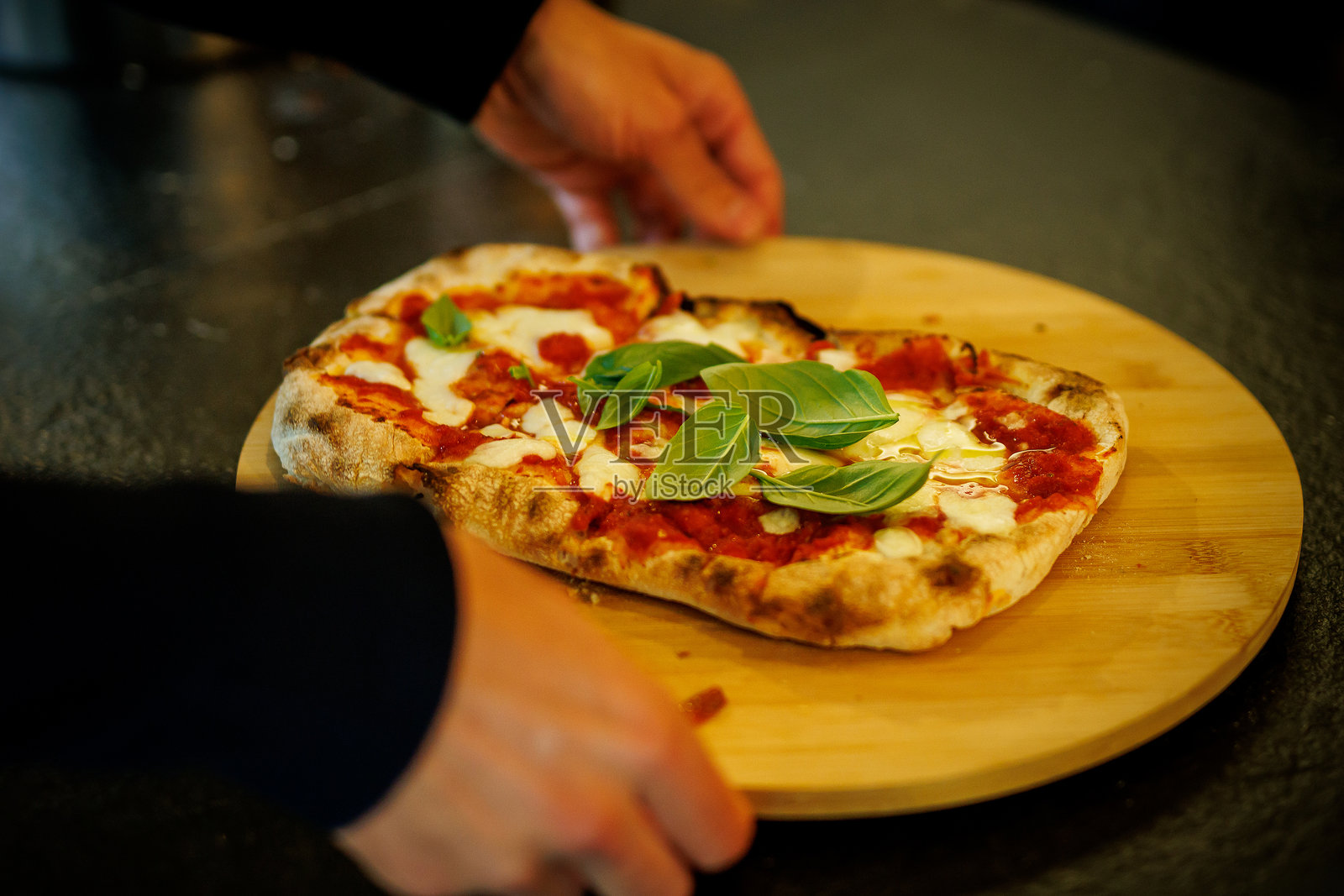 新鲜出炉的玛格丽特披萨配罗勒叶照片摄影图片