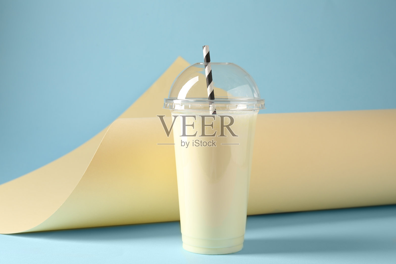 塑料杯装的美味奶昔，背景为彩色照片摄影图片