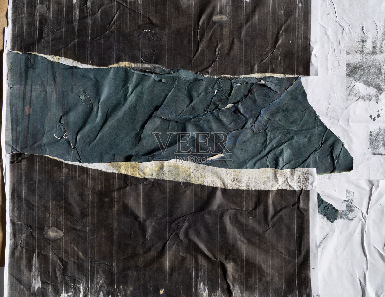 撕毁的带有黑蓝色印花的纸质海报粘贴在白色脏纸上照片摄影图片