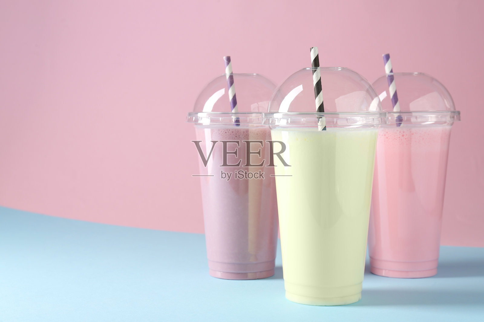 塑料杯中美味的奶昔，置于彩色背景上，留有文字空间照片摄影图片