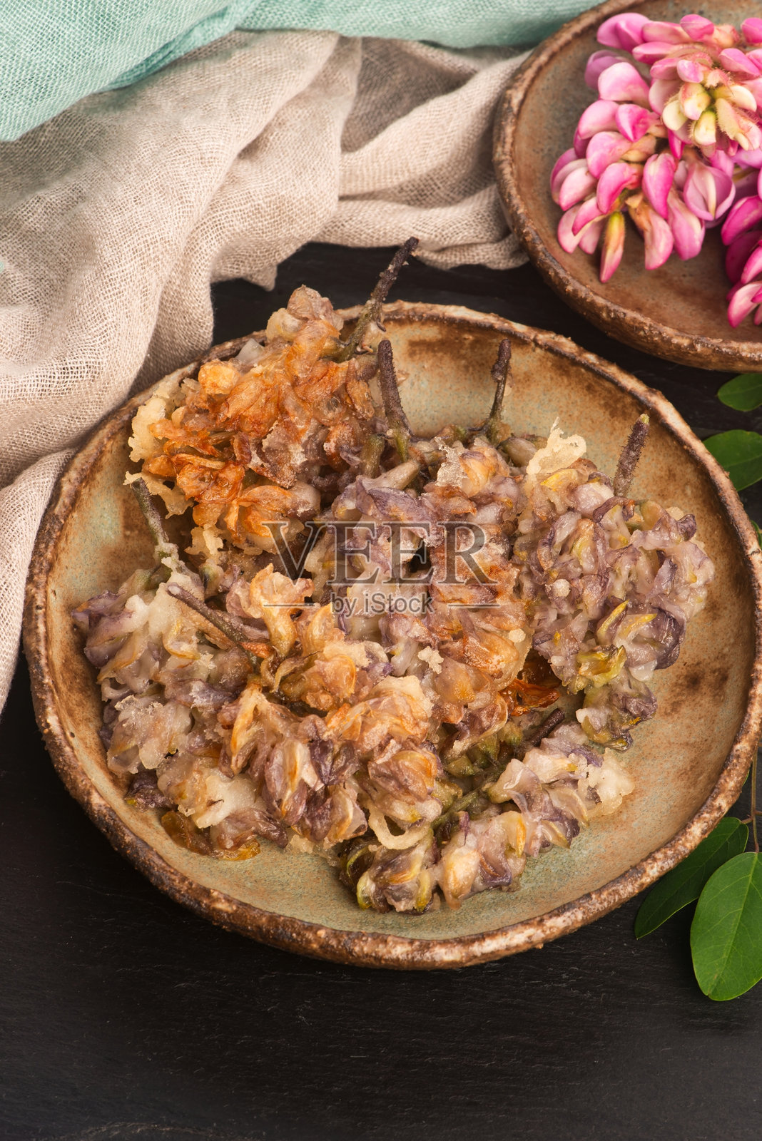 手工陶瓷盘上的粉红金合欢花天妇罗照片摄影图片