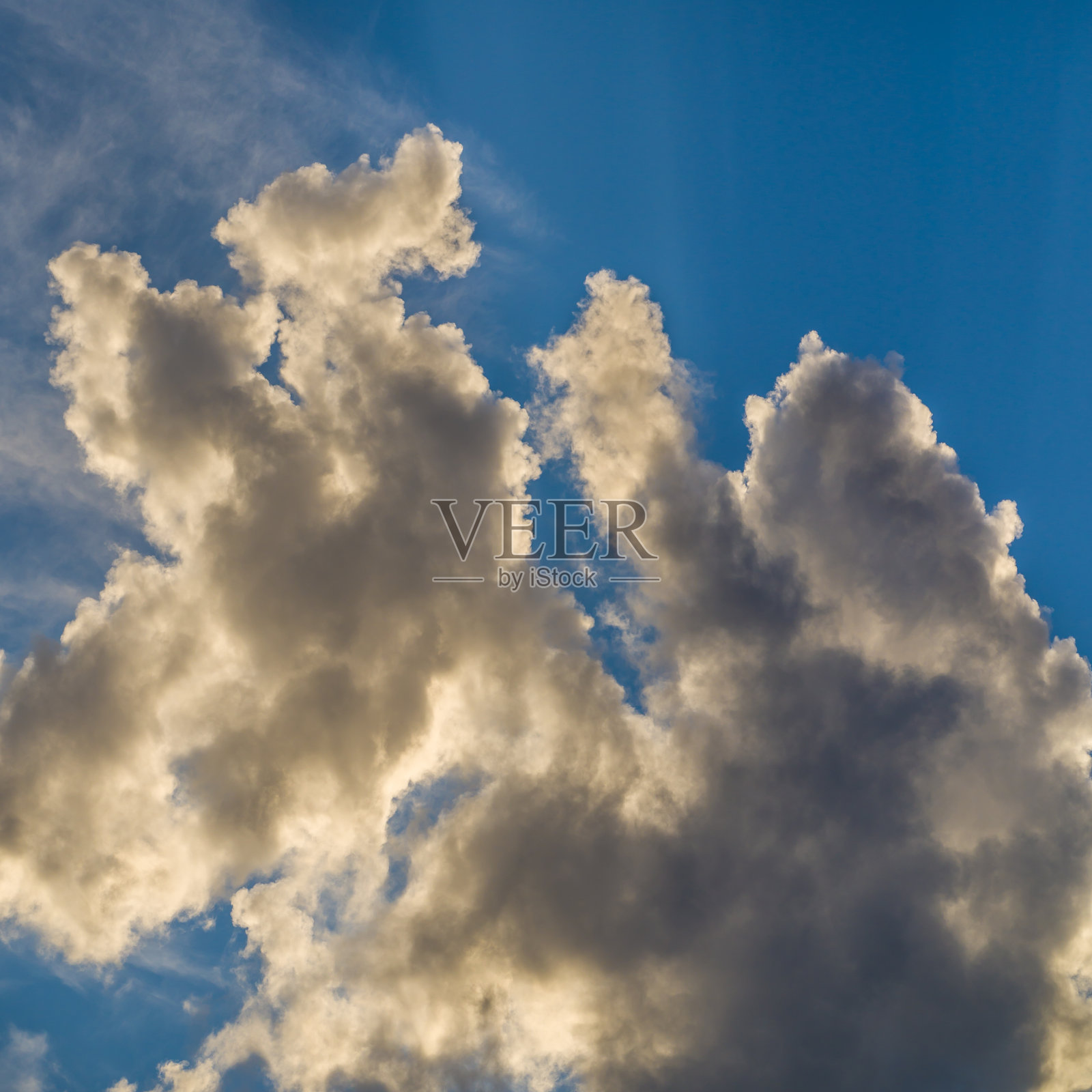 阳光下的雨云在蓝天上照片摄影图片