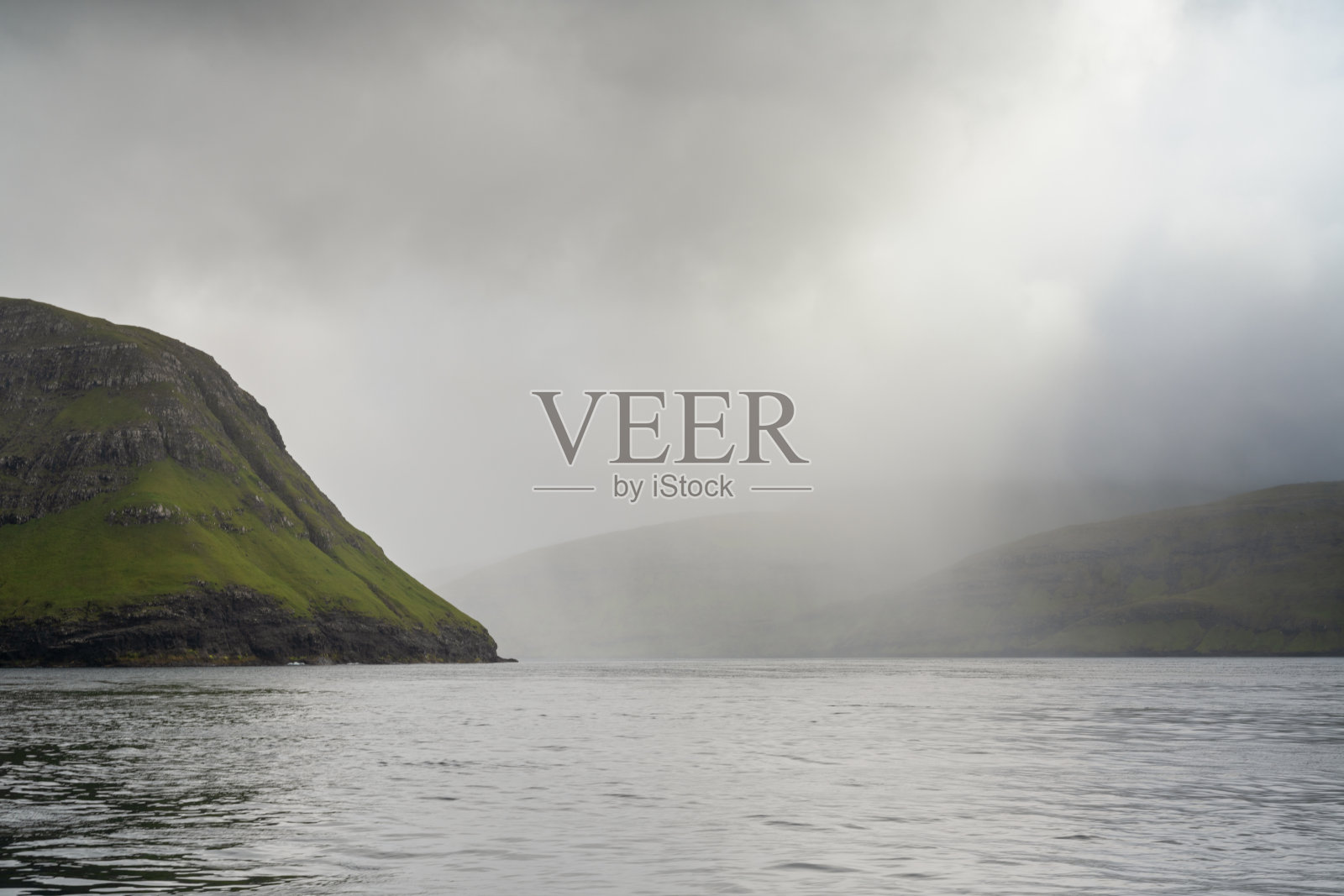 雾蒙蒙阴天中，法罗群岛斯特莱默岛上标志性的韦斯特曼纳峡湾（Vestmannabjorgini）或韦斯特曼纳悬崖（Vestmanna Cliffs）的景色照片摄影图片