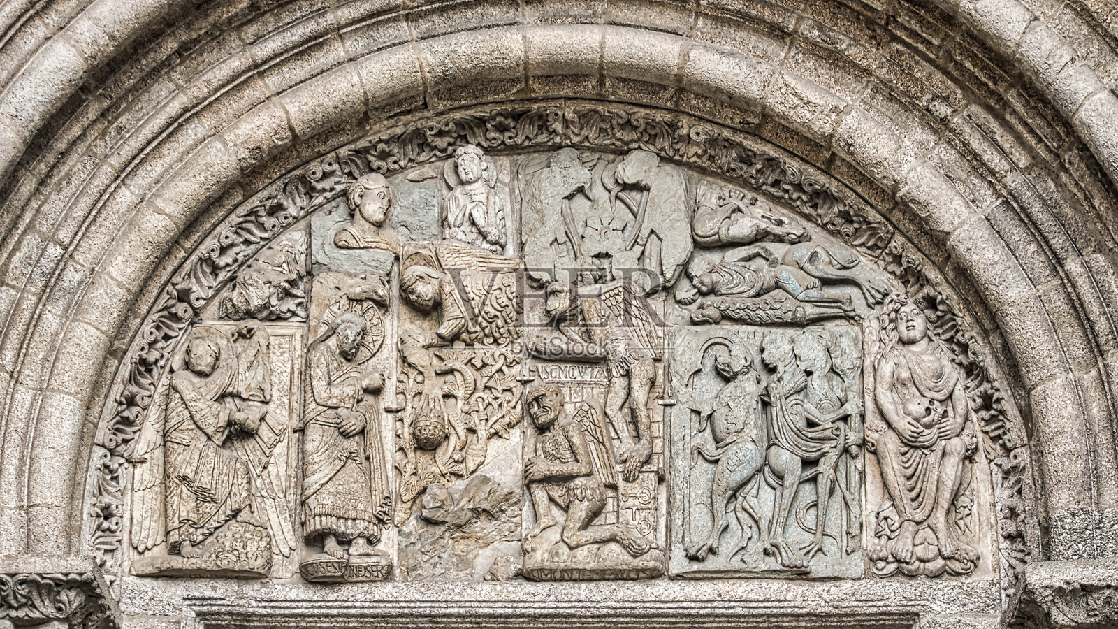 西班牙圣地亚哥-德孔波斯特拉大教堂Platerías门上雕塑和浮雕特写，其中一个山形墙上刻有圣经场景照片摄影图片