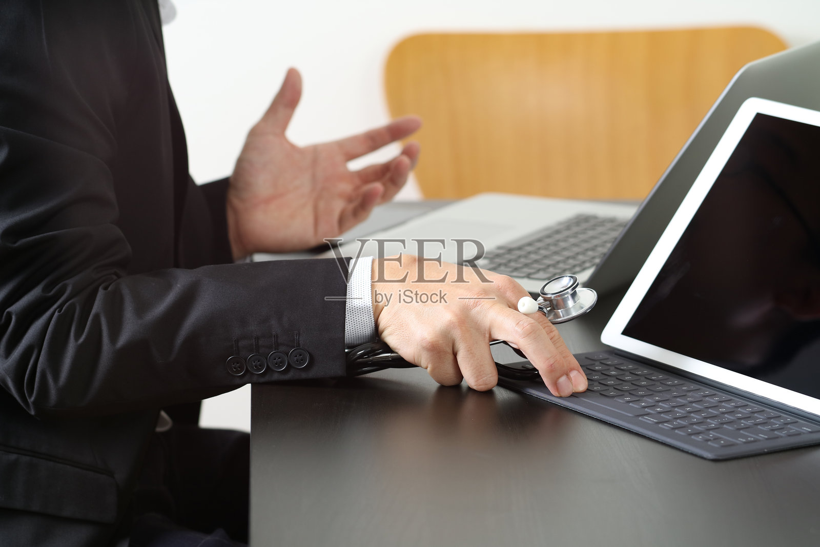 医生手持听诊器，操作数字平板电脑照片摄影图片