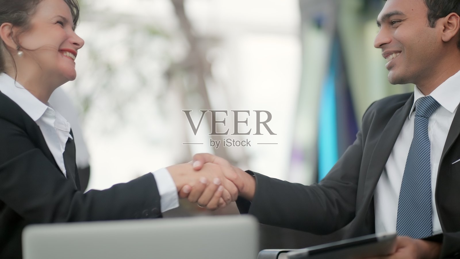 商业顾问和经理在公司办公室开会，评估业绩报告，审阅财务数据，并制定下一季度的战略。会议氛围体现了专业、高效和共同承担的责任。照片摄影图片