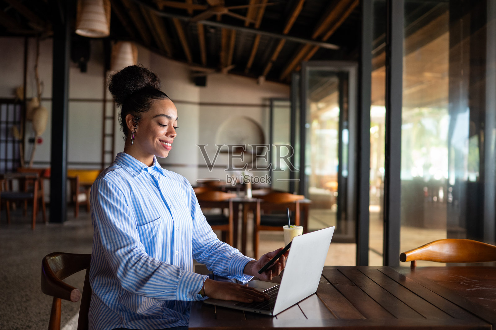一位女企业家在餐厅用笔记本电脑远程办公，管理着她的企业。照片摄影图片