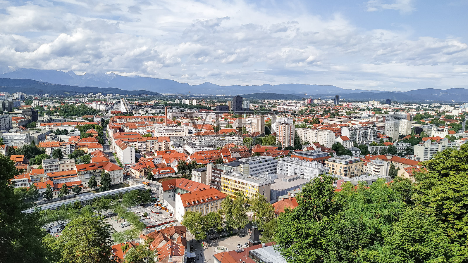 红顶城市景观鸟瞰图,背景为绿色山丘照片摄影图片
