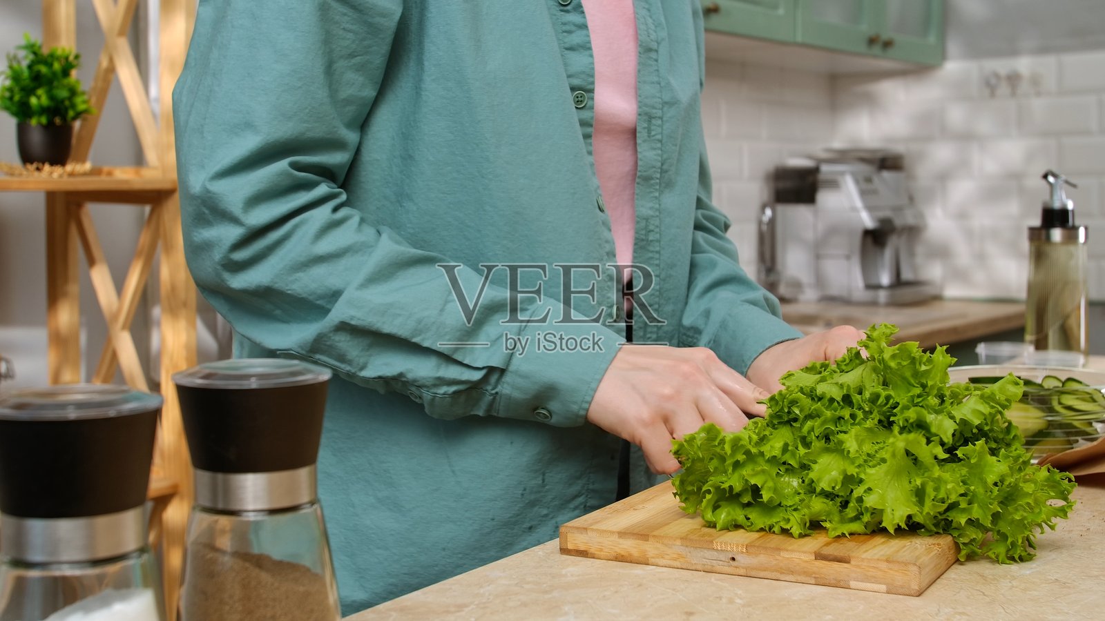 女子在厨房里切新鲜的绿色生菜照片摄影图片