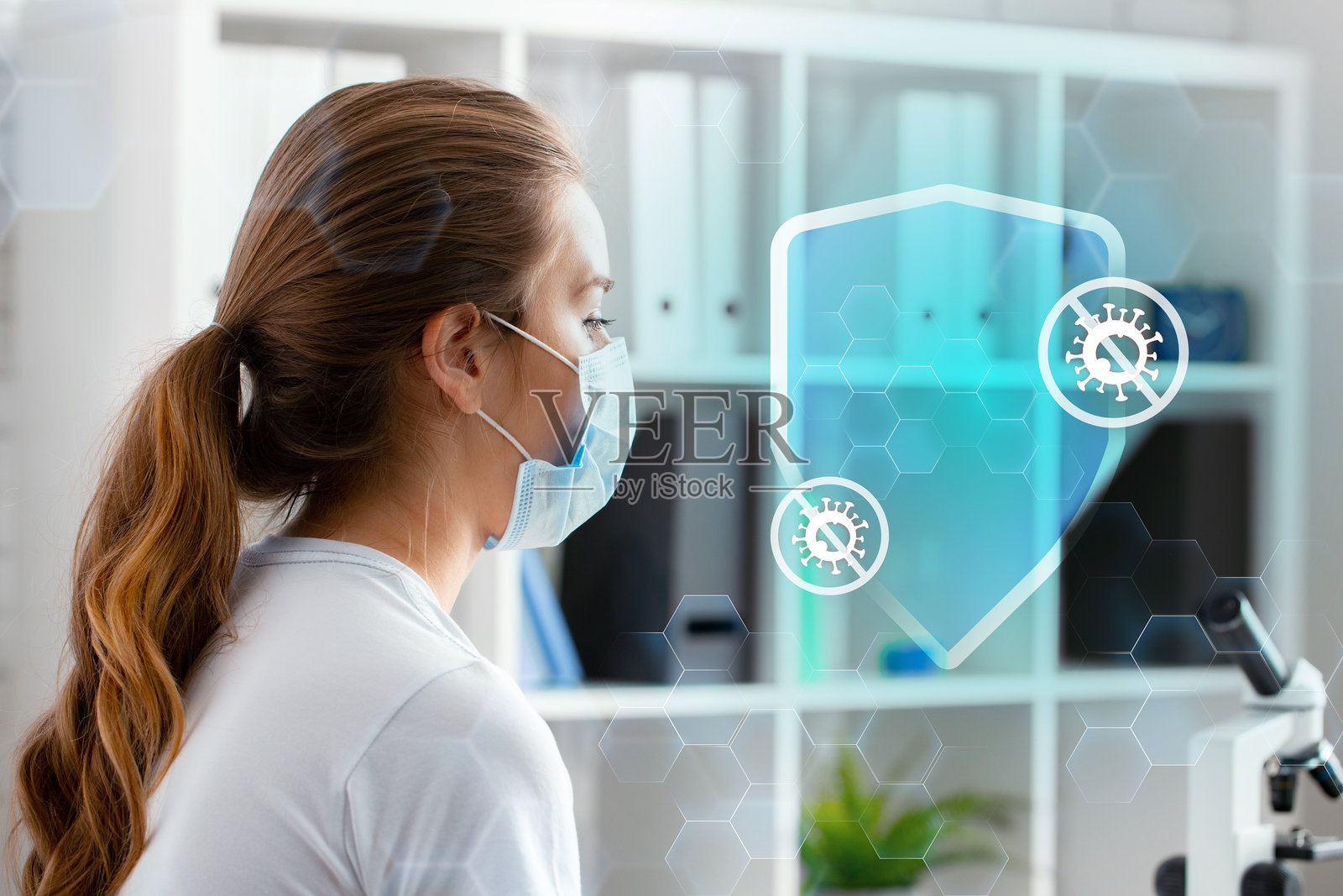 一位医疗专业人员在现代实验室环境中通过显微镜分析数据照片摄影图片