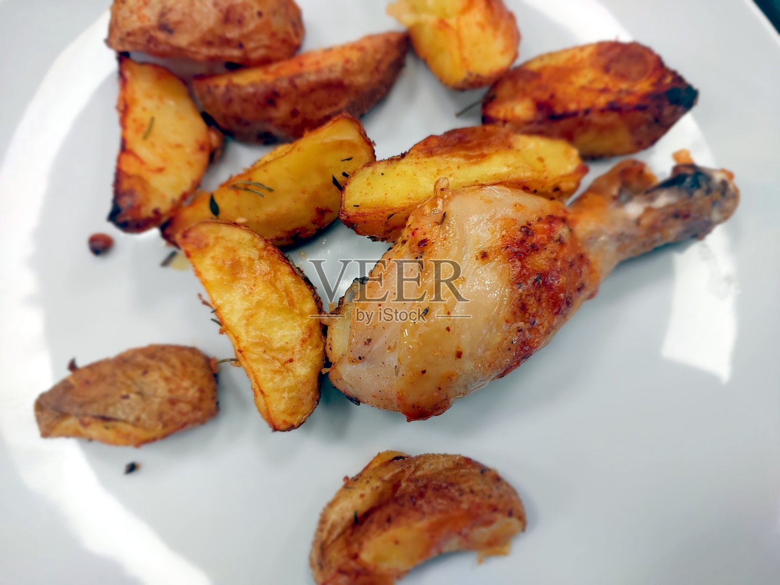 美味的炸鸡腿配酥脆烤土豆，构成令人满意的一餐照片摄影图片