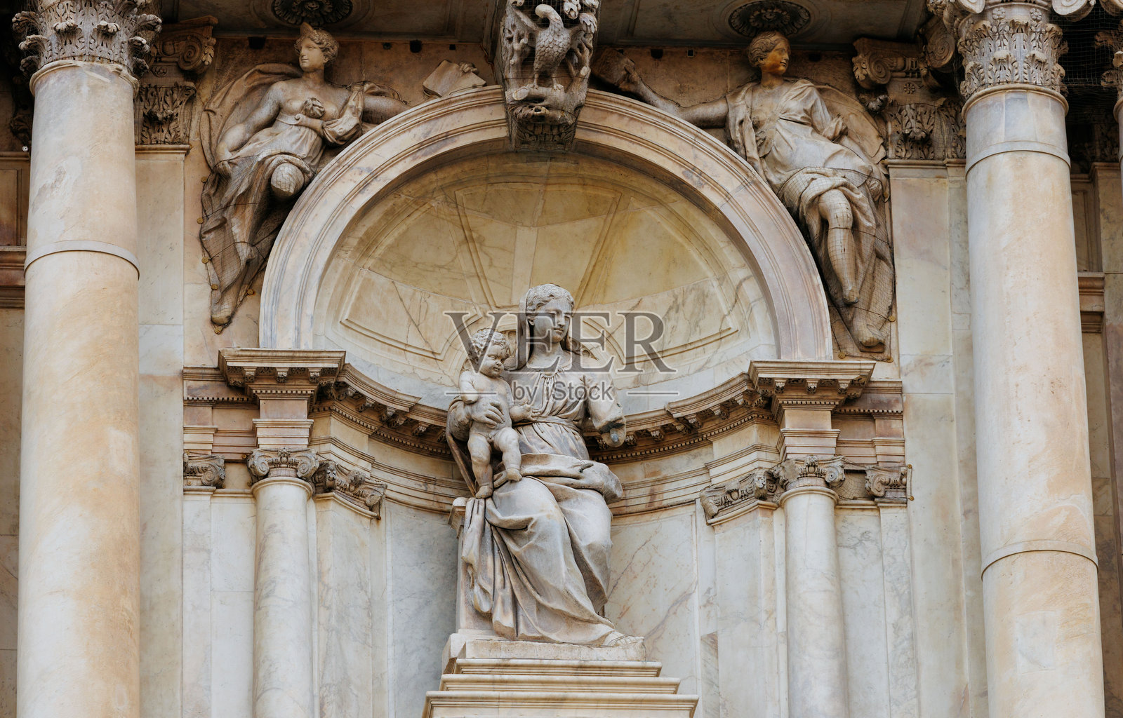 圣母子大理石雕像，周围环绕着华丽的柱子和精美的雕刻，展现了古典建筑和艺术工艺。照片摄影图片