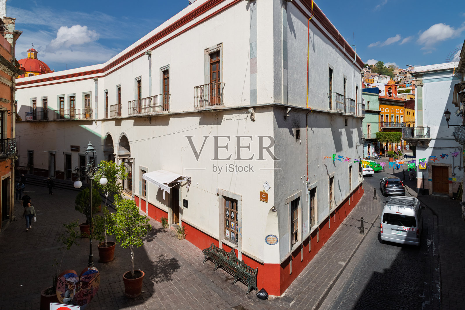从空中俯瞰历史中心，节日气氛的街道角落，有殖民时期建筑、行人及停放的货车照片摄影图片
