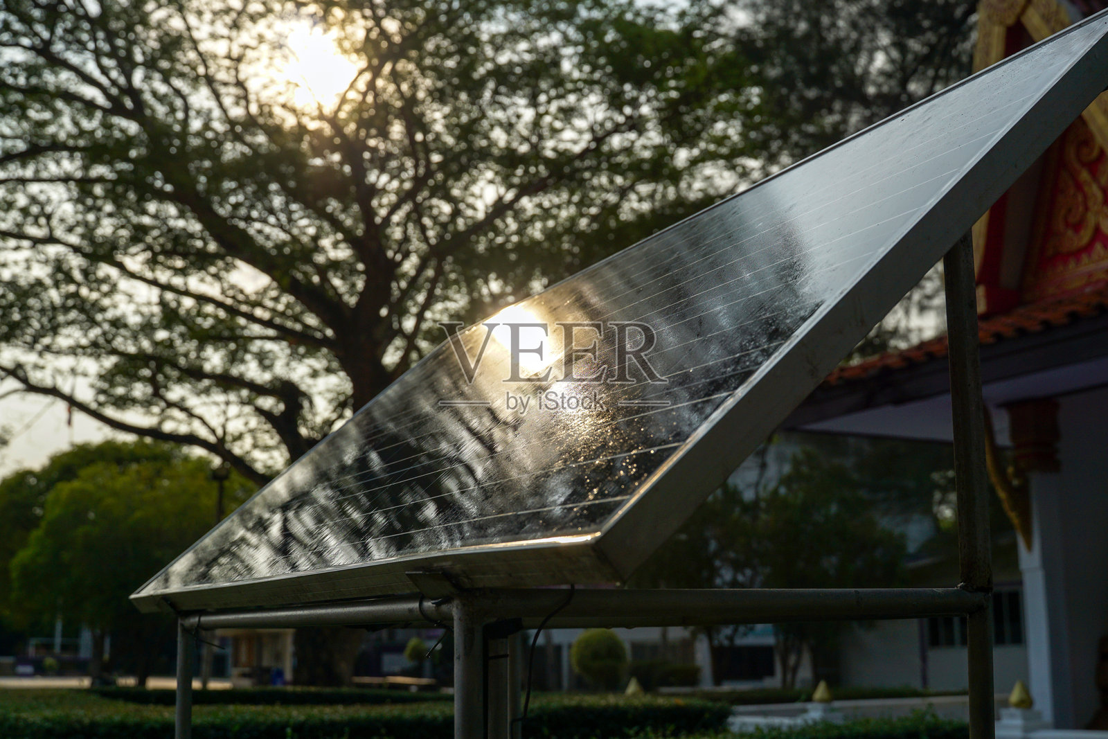 夕阳映照在湿润的太阳能电池板上，可再生能源概念照片摄影图片