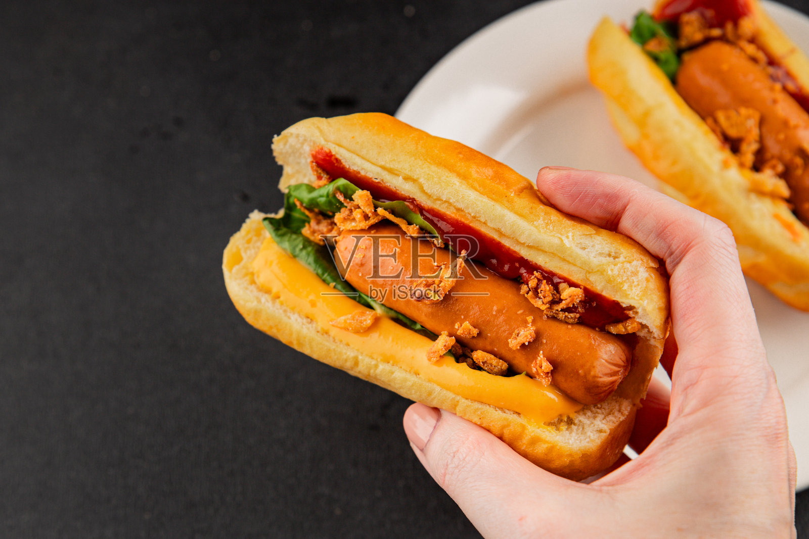 烤肠、炸洋葱、香肠、面包、酱料，美味的快餐小吃，新鲜诱人，乡村风格的餐桌背景，俯视角度，留有复制空间照片摄影图片