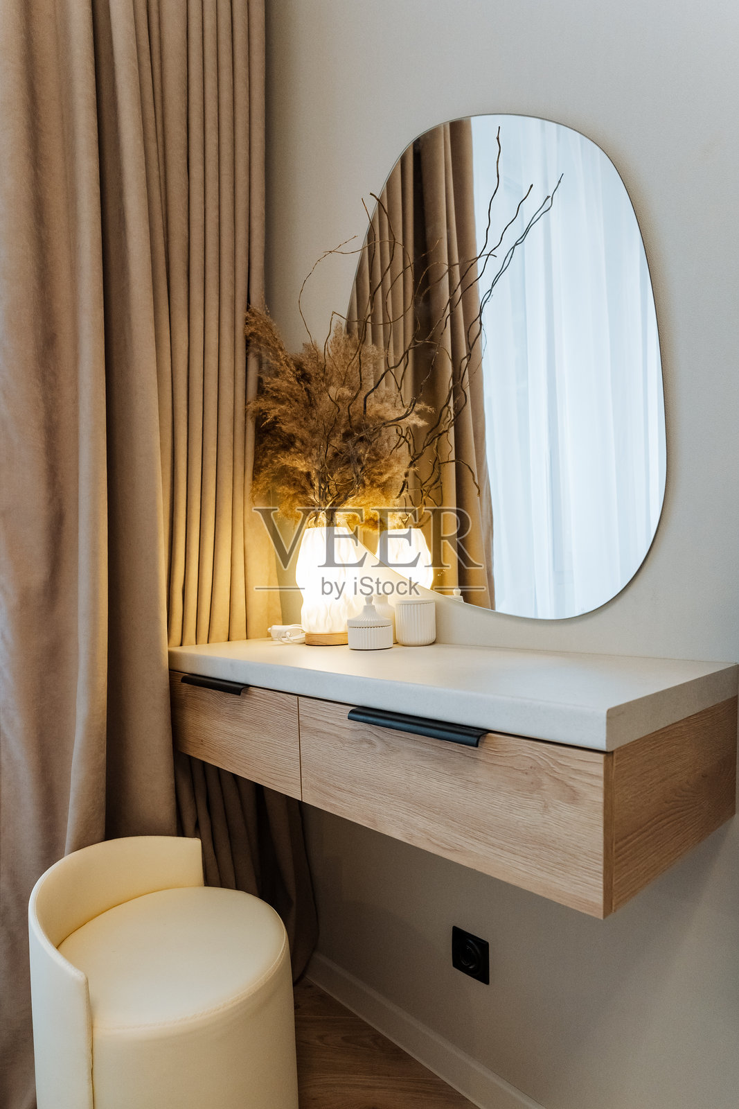 在一间舒适且设计精良的卧室里，摆放着一张制作精美的梳妆台，配有时尚的镜子和舒适的凳子，营造出一个完美的梳妆空间。照片摄影图片