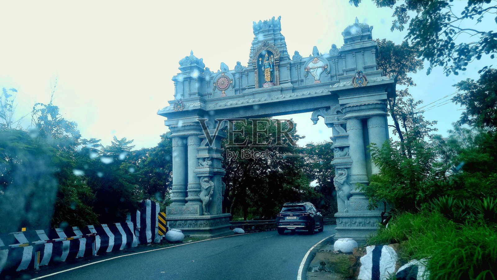 季风季节，蒂鲁马拉山区的雾气弥漫的山路，车辆穿梭于拱门，绿意盎然。照片摄影图片
