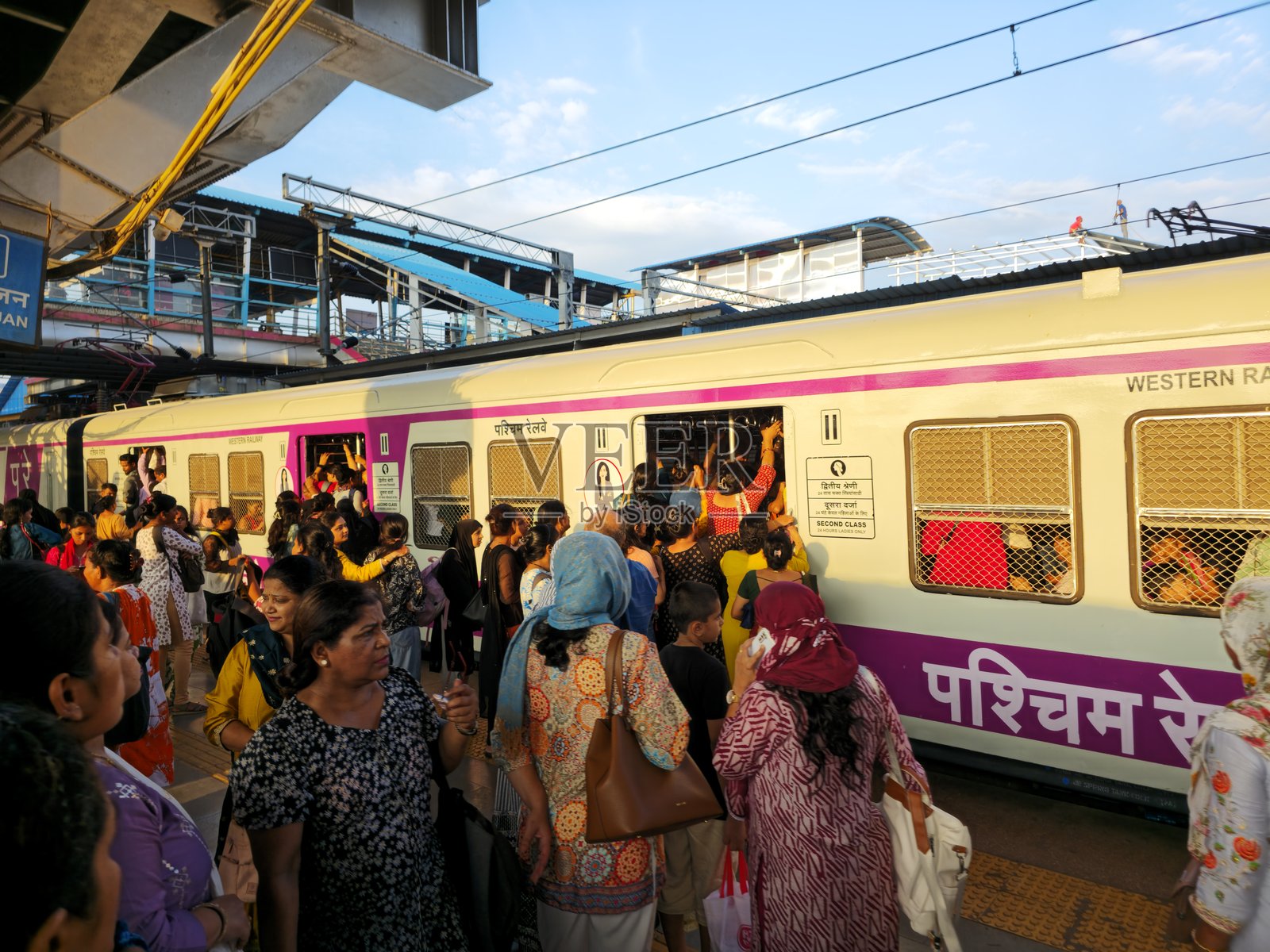 乘客在晚高峰时段，于孟买郊区火车站拥挤的女士车厢内登车照片摄影图片