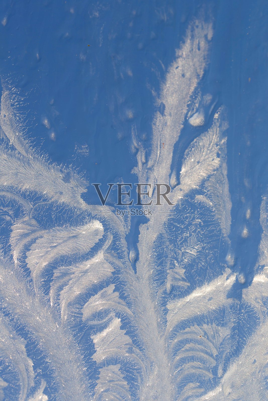 冬季结冰的窗户，霜花形成各种图案。照片摄影图片