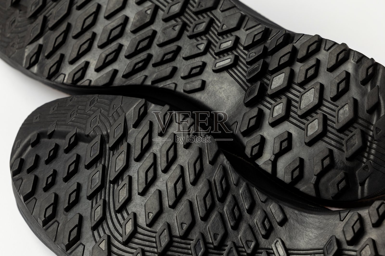 白色背景上的登山靴鞋底。防滑纹理细节清晰可见。照片摄影图片