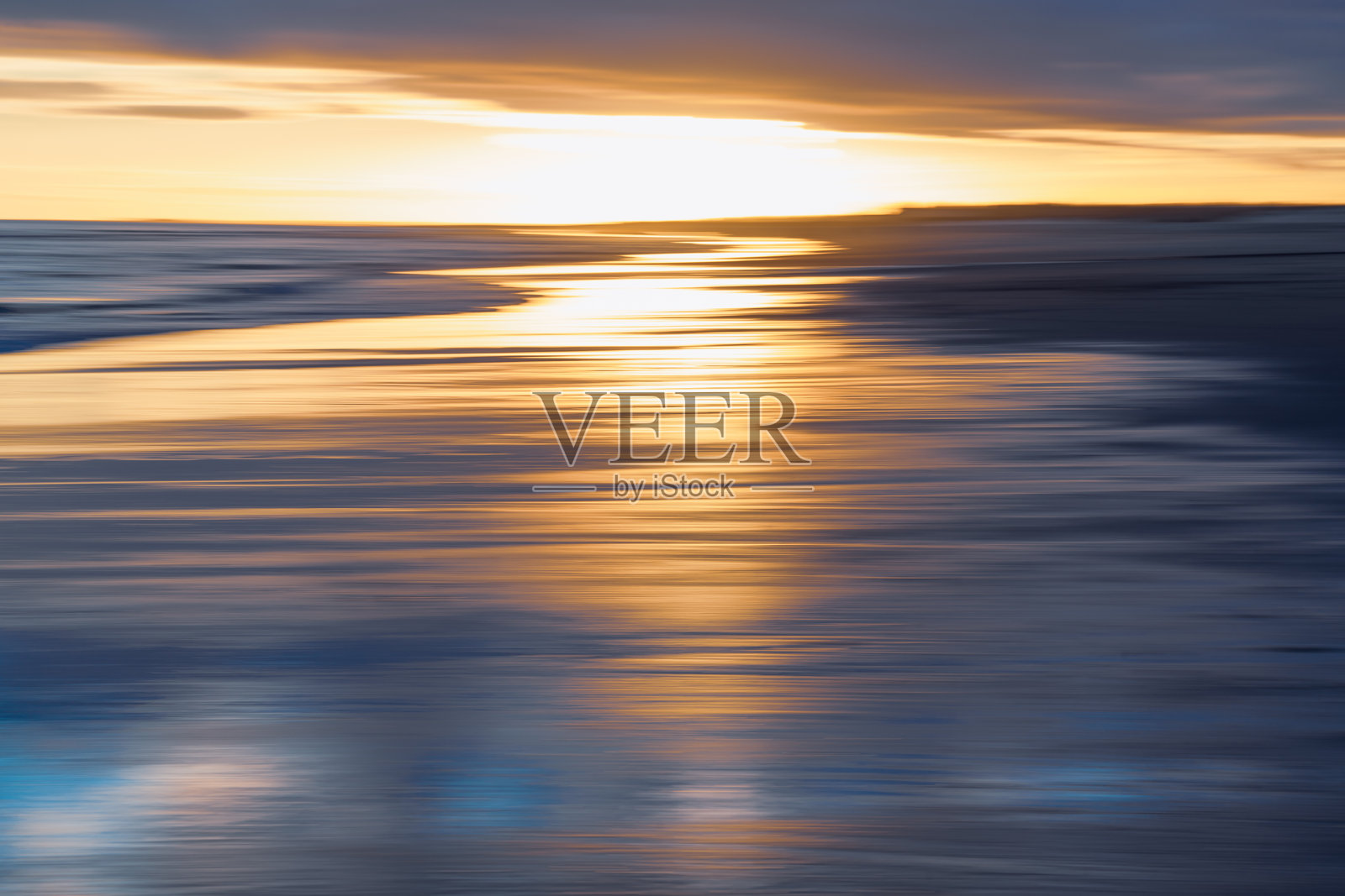 日落时分，模糊的金色和蓝色色调构成的抽象海景。照片摄影图片