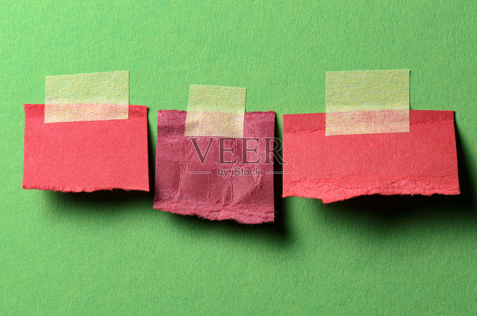 绿色背景上带有胶带的空白红色便签纸，留有文字复制空间照片摄影图片