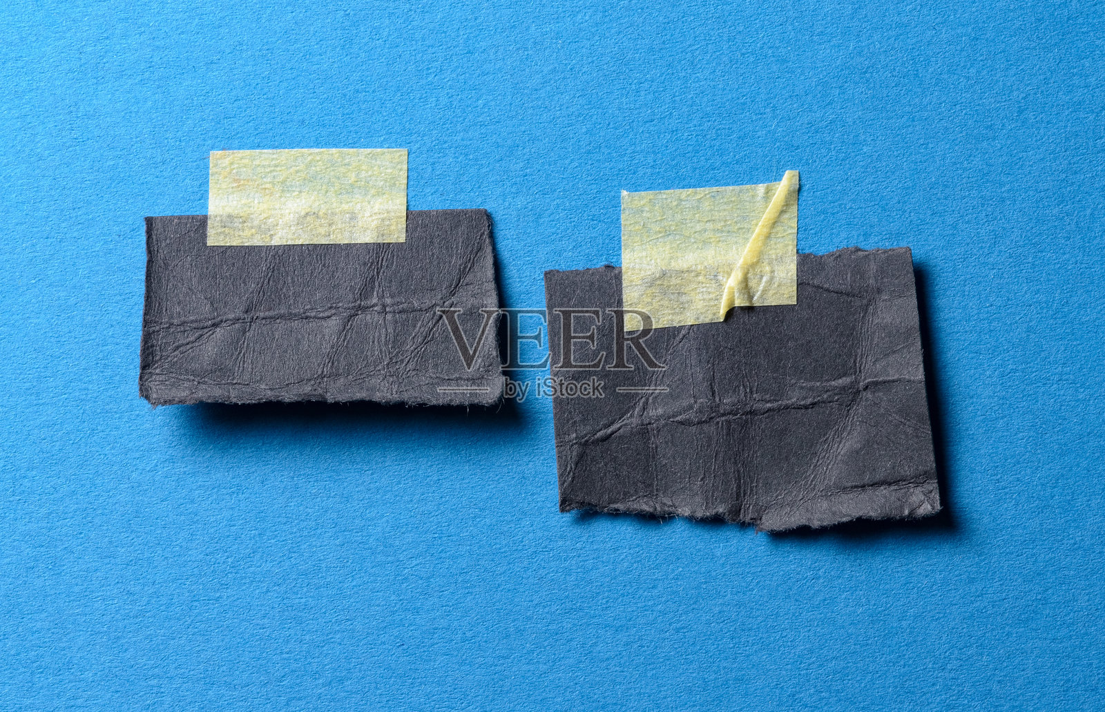 带有复制文本空间的黑色便签纸备忘录提醒，附有胶带，背景为蓝色照片摄影图片