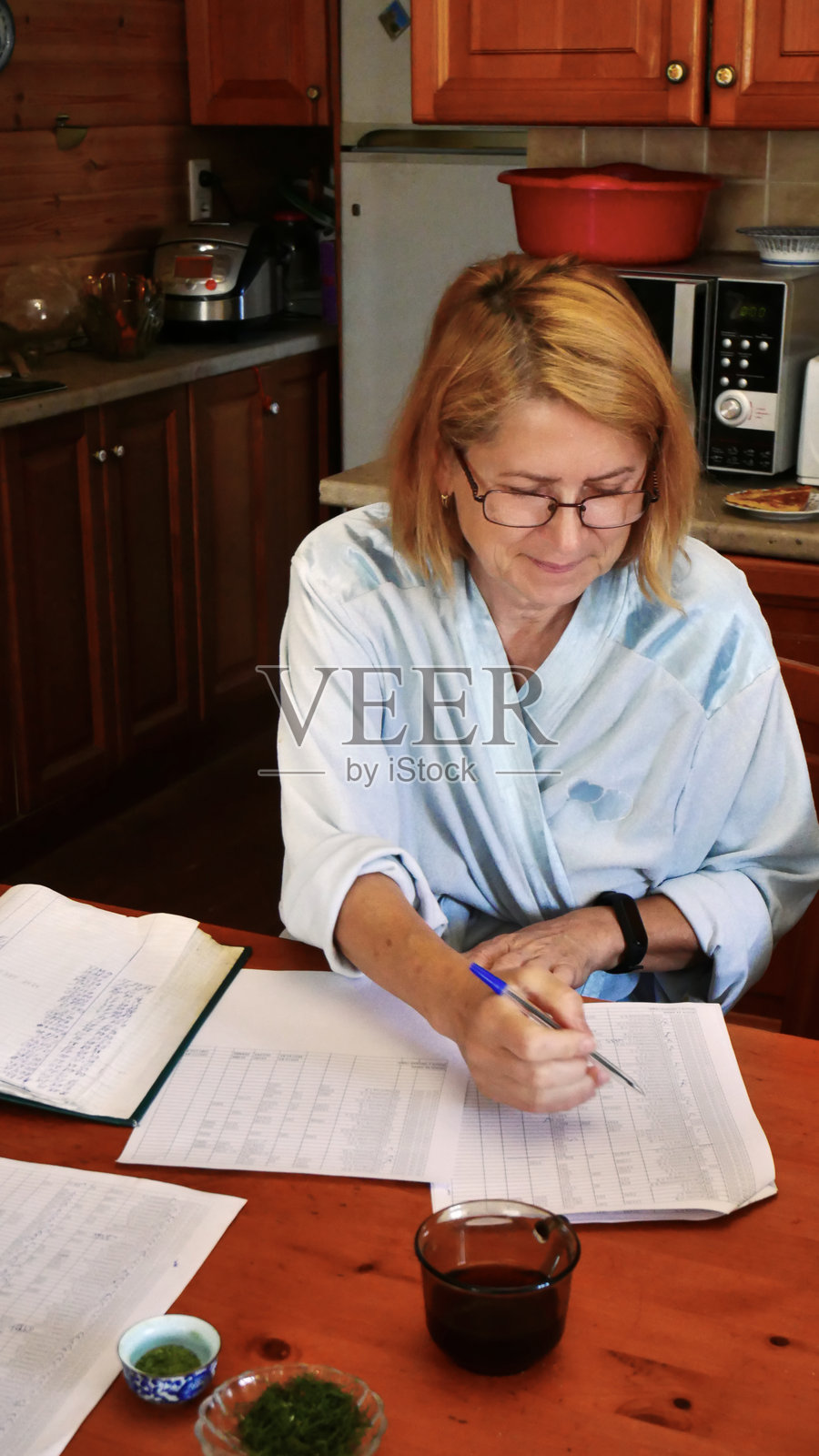 家庭厨房里专注于处理文书工作的女性照片摄影图片