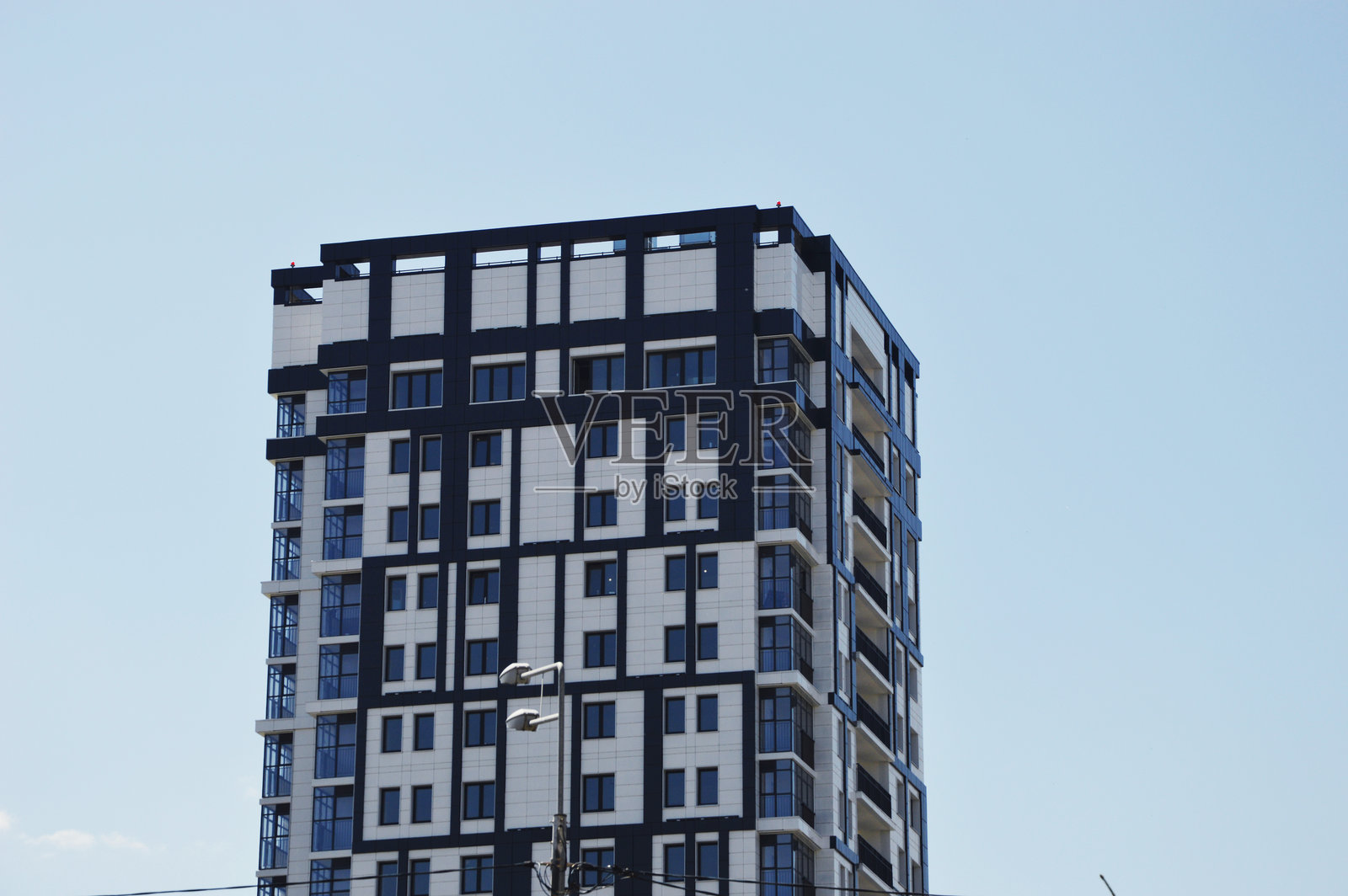 带有灰色和白色装饰元素的灰色和白色高层住宅公寓楼。现代城市建筑。照片摄影图片