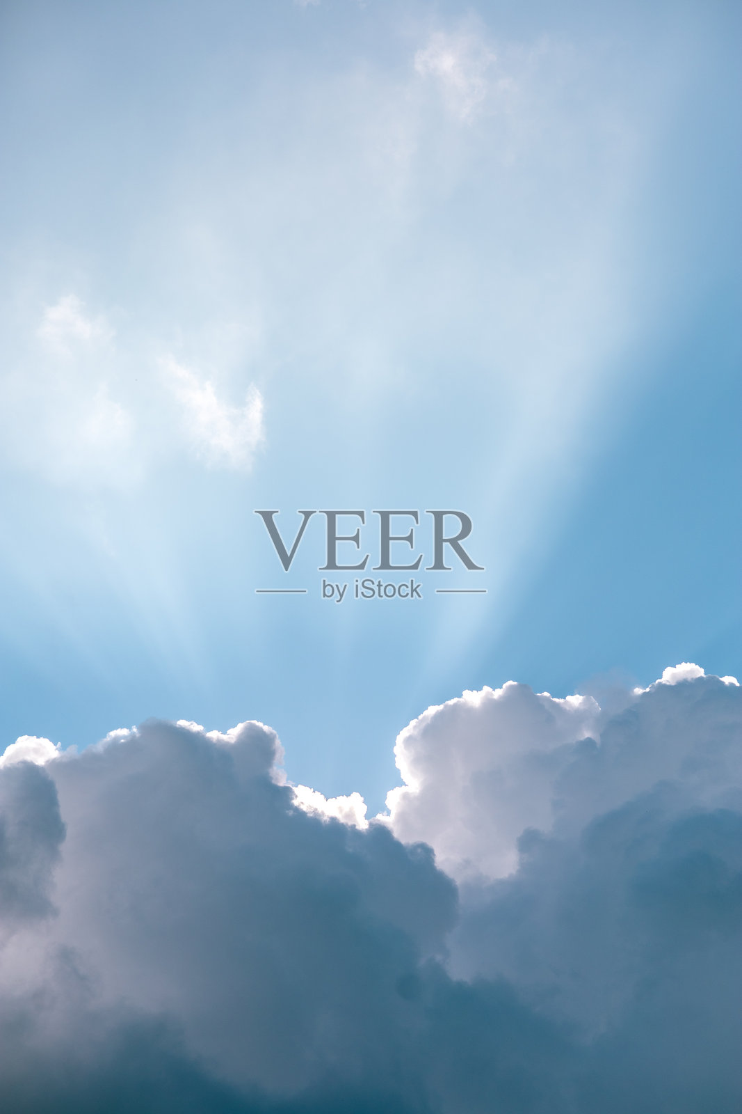 明亮的蓝天中，阳光穿透云层，营造出宁静祥和的天堂般氛围。照片摄影图片