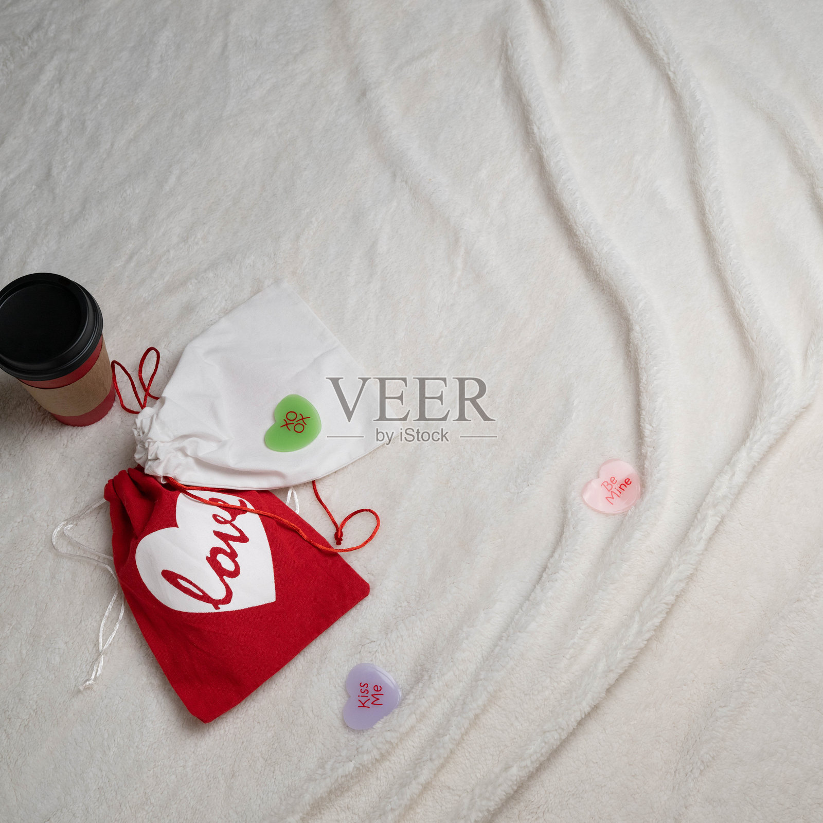 情人节礼物和一杯咖啡放在白色仿毛毯上。照片摄影图片